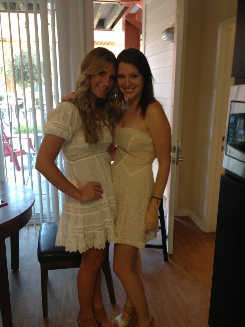 Claytie and Conley, arms around each other, in white dresses